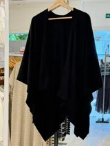 Ruana de tejido de punto fino en color beige, con diseño abierto y caída fluida.