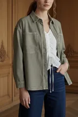 Sobrecamisa de algodón peinado en color verde oliva, con corte oversize, cuello camisero, cierre frontal con botones metálicos y bolsillos frontales tipo parche.