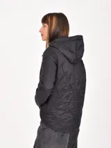 Campera negra con capucha, diseño acolchado con costuras decorativas, cierre frontal y bolsillos delanteros.