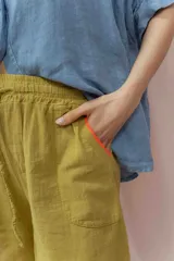 Short blanco de calce relajado con cintura elástica y lazo regulable. Presenta bolsillos amplios con ribete interior de color naranja neón.