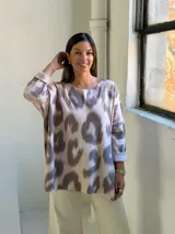 Sweater de punto con estampado abstracto tipo animal print en tonos gris y beige, de corte holgado, cuello redondo y mangas tres cuartos con dobladillo.