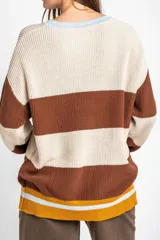 Sweater oversize de tejido de punto con diseño de rayas horizontales anchas en color beige y azul marino, cuello redondo marrón y puños y dobladillo en marrón con líneas beige y blancas.