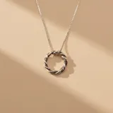 Collar de plata 925 con cadena de eslabones finos y dije circular con diseño trenzado.