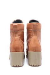 Borcego acordonado color marrón de cuero con suela beige y taco cuadrado.