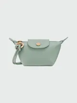 Monedero Longchamp de la línea Le Pliage Xtra, confeccionado en cuero color verde menta. Presenta una solapa con botón a presión metálico dorado grabado con el logo de la marca y un tirador de cierre circular con el icónico caballo de Longchamp.