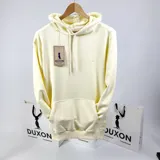 Canguro amarillo pastel con capucha y bolsillo delantero, con logo de la marca bordado en el pecho.