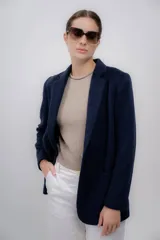 Blazer azul marino de baby alpaca con solapas de muesca, cierre frontal con un botón y bolsillos de parche.