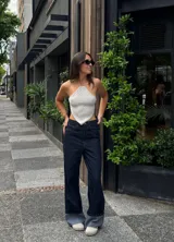 Top de punto hecho a mano, color gris perlado, con diseño de escote halter y forma triangular asimétrica.