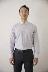 Camisa de vestir Florenzi de manga larga, con diseño de rayas verticales finas en tonos gris y blanco. Presenta cuello clásico, cierre frontal con botones y puños abotonados.