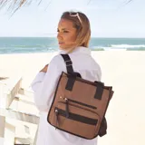 Mochila y cartera híbrida confeccionada en nylon de color beige con detalles y correas en negro. Posee dos asas superiores para llevar al hombro y correas traseras ajustables para usar como mochila. Presenta dos bolsillos frontales con cierre de cremallera y tiradores largos.