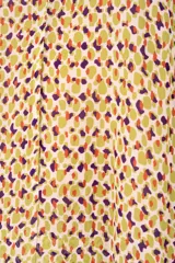 Vestido corto con estampado abstracto en tonos amarillos, marrones y violetas, con cuello halter que se ata al cuello y espalda descubierta.