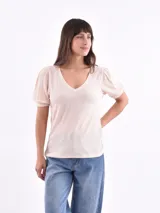 Blusa color crema con escote en V y mangas cortas abullonadas.