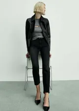 Jeans mom fit de tiro alto y corte recto, confeccionados en denim negro con tejido elástico. Cuentan con diseño clásico de cinco bolsillos, trabillas para cinturón y cierre frontal con cremallera y botón metálico.
