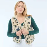 Chaleco sin mangas confeccionado en tejido tipo corderito, con estampado floral en tonos azules y verdes sobre base beige. Presenta escote en V, cierre frontal con botones a presión y ribetes en color crema.