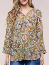 Blusa holgada de rayón con estampado de arabescos en tonos marrón, mostaza, rosado y celeste. Presenta escote en V con cuello mao, mangas tres cuartos y dobladillo asimétrico.