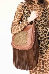 Cartera de hombro con diseño artesanal, confeccionada en una combinación de cuero vacuno color tabaco, gamuza color chocolate y cuero con estampado animal print. Presenta una tapa frontal con apliques metálicos, flecos largos en el frente y laterales, y cierre principal superior. Incluye una correa corta fija y una correa larga extensible y desmontable.