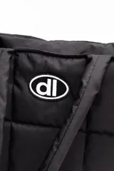 Bolso plateado acolchado con logo ovalado negro y blanco.