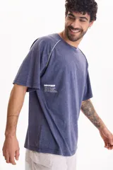 Remera de manga corta raglán con lavado acid wash color azul, de corte holgado, cuello redondo y estampa tipográfica en la espalda.