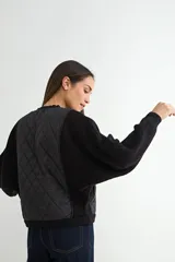 Campera tipo bomber con frente acolchado en diseño de rombos y mangas de tejido de punto acanalado. Presenta cierre frontal metálico y cuello, puños y ruedo en tejido elástico.