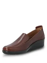 Zapato tipo slip-on de cuero liso lustrado color marrón, con diseño de calce fácil y suela de caucho termoplástico con taco de 4 cm.