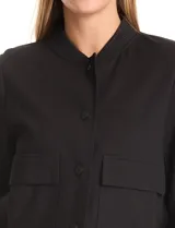 Campera tipo bomber color beige, con cuello redondo, cierre frontal con botones a presión y bolsillos delanteros. Presenta puños y ruedo acanalados.