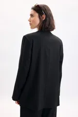 Blazer sastrero de lino color negro, con solapas clásicas, bolsillos delanteros con solapa y diseño de corte recto.