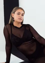 Vestido negro de tul con mangas largas y largo por debajo de la rodilla.