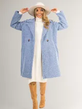 Tapado celeste de paño con doble botonadura, cuello solapa y bolsillos laterales.