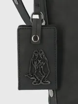 Cartera tipo tote de la marca Hush Puppies, color negro, con diseño minimalista y correa ajustable. Incluye un colgante decorativo con el logo del perro característico de la marca.