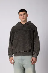 Buzo canguro oversize con efecto lavado desgastado, confeccionado en friza pesada. Presenta diseño con recortes, capucha y puños acanalados.