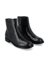 Botín de caña corta confeccionado en cuero con textura de cocodrilo, con costuras a contratono, suela baja y punta cuadrada.