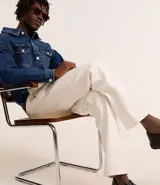 Campera trucker de jean azul oscuro, con cuello tradicional, cierre frontal con botones, cuatro bolsillos y mangas largas.