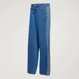 Pantalón Adidas Firebird de denim azul de corte holgado, con tiro medio y las icónicas tres tiras blancas a lo largo de los laterales de las piernas.