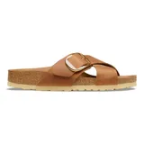 Sandalias Birkenstock modelo Siena Big Buckle, color cognac. Presentan un diseño de correas cruzadas en cuero con una hebilla grande metálica dorada ajustable. Poseen la clásica plantilla anatómica de corcho y látex con suela de goma antideslizante.