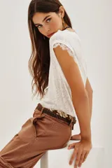 Musculosa blanca de lino con cuello redondo y detalle de encaje en las mangas.