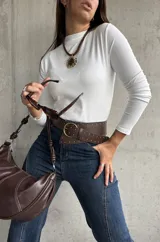 Polera de cuello alto y manga larga, confeccionada en tejido elástico de color blanco, con ajuste al cuerpo.