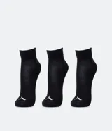 Pack de tres pares de medias deportivas Puma de caña corta, confeccionadas en tejido de algodón con textura. Incluye un par negro, uno blanco y uno gris, cada uno con el logo de la marca en el talón y el nombre en la parte superior.