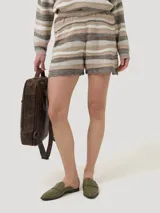 Short de tejido de punto con diseño de rayas horizontales irregulares en tonos tierra, beige y blanco. Presenta cintura elástica y terminación con borde festoneado.