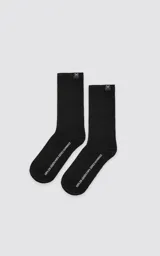 Medias negras de corte alto y tejido acanalado, confeccionadas en una mezcla de algodón y spandex, con una pequeña etiqueta distintiva con forma de tijera en el borde superior.