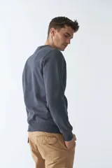 Buzo de felpa color rosa con logo estampado, cuello redondo, mangas largas y puños.