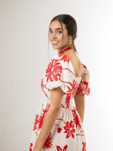 Vestido largo azul marino con estampado floral blanco, escote cuadrado con nido de abeja en el pecho y mangas abullonadas cortas.