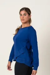 Buzo deportivo celeste de algodón, con cuello redondo y terminación en volado cruzado en el ruedo.