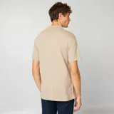 Remera polo de piqué de algodón color beige, con cuello clásico, manga corta y cierre de tres botones.