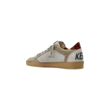 Championes Golden Goose modelo Ballstar de estilo urbano, confeccionados en cuero blanco con efecto desgastado, detalles en gamuza gris y marrón, estrella lateral en color negro y suela de goma con inscripciones manuscritas.
