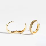 Par de aros tipo argolla dorados con cristales claros en uno de sus lados, y calado de hojitas del otro.