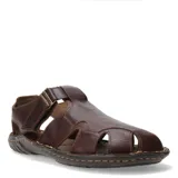 Sandalias de cuero marrón con diseño cerrado en la puntera y aberturas laterales. Posee ajuste con velcro en el talón y suela de goma con costuras visibles.