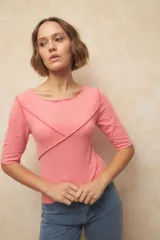 Remera negra de manga tres cuartos, escote redondo y detalle de costuras superpuestas de forma asimétrica.