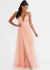 Vestido largo de tul en color salmón, con escote en V profundo, tirantes finos y falda con tajo frontal.