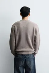 Jersey de punto con textura efecto pelo, corte boxy fit, cuello redondo y manga larga con acabados en rib.
