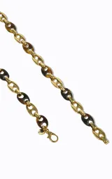 Cinturón de cadena para mujer elaborado en metal y acrílico, con eslabones ovalados bicolor en tonos dorados y carey, caída flexible y detalle de cadena colgante en el lateral.